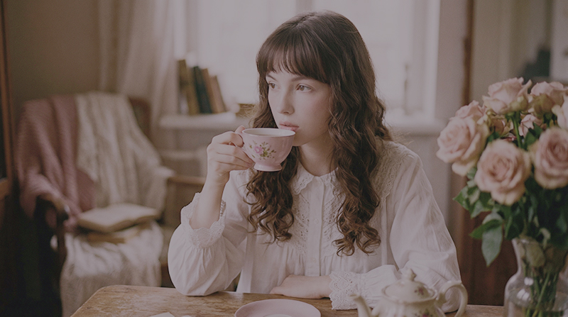 brunette girl sipping tea in her room