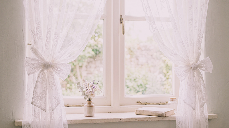 soft lace curtains with ribbons in front of a window